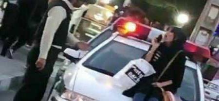 با‌زداشت زن جوانی که روی خودروی پلیس نشست + عکس