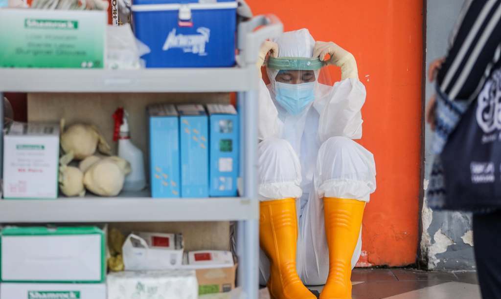 استراحت یکی از پرسنل بهداشتی بعد از جمع آوری سواب + عکس