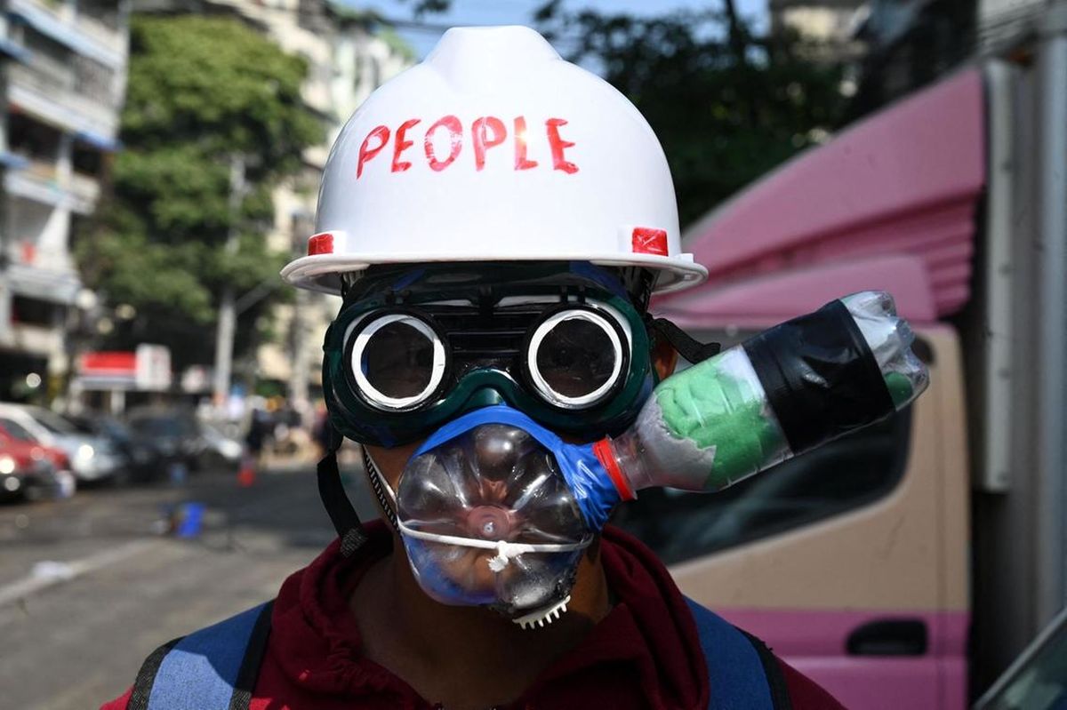حفاظت معترض میانماری با استفاده از ماسک دست ساز مقابل گاز اشک آور در تظاهرات.
