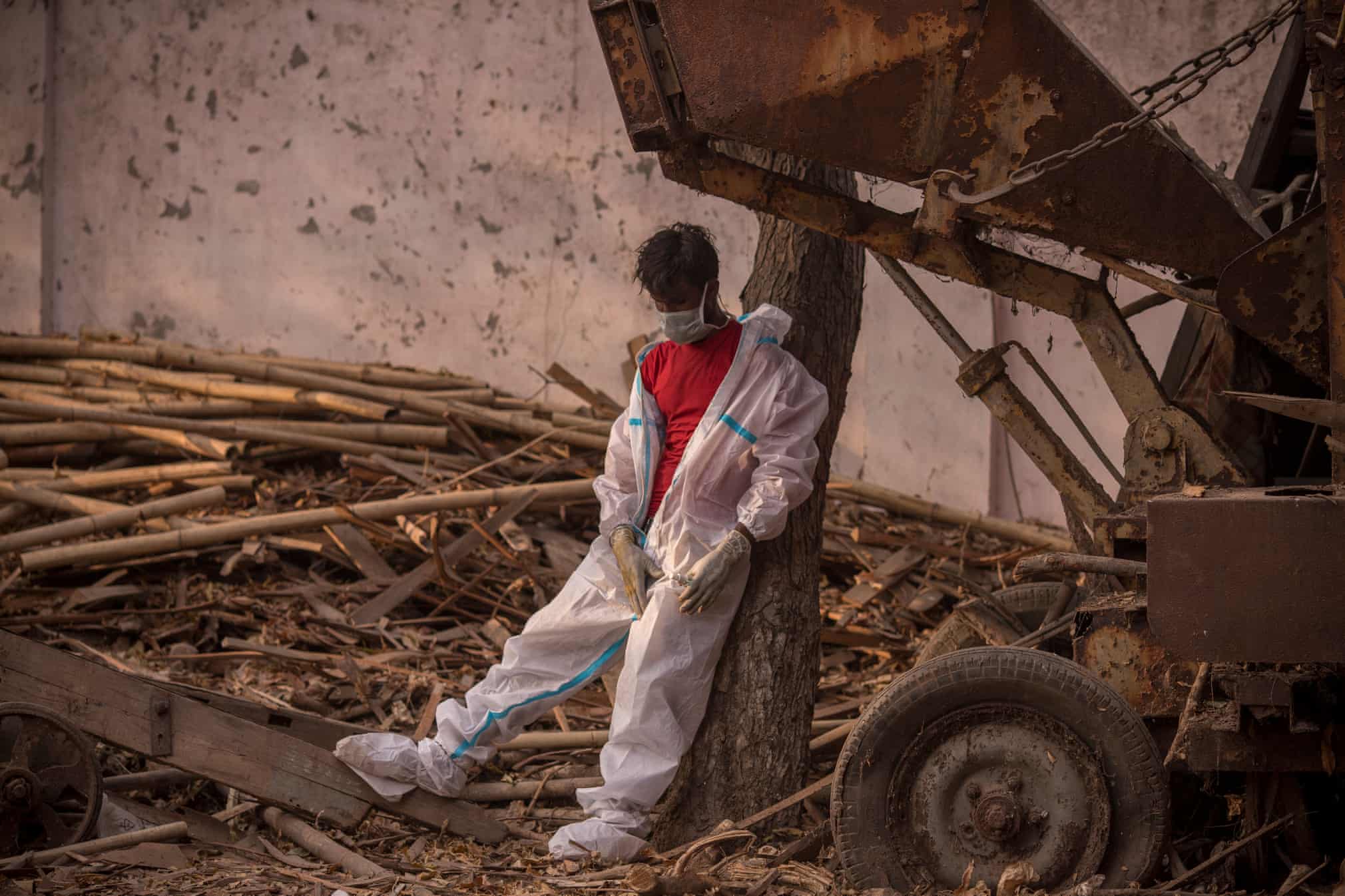 کارگر خسته و بی رمق هندی در محل سوزاندن اجساد کرونایی + عکس