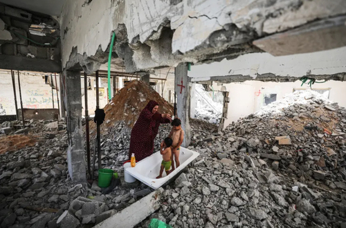 مادر فلسطینی در حال شستشوی فرزندان در خانه ویران شده + عکس