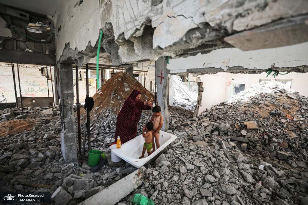  حمام کردن دو کودک فلسطینی در میان آوارها + عکس