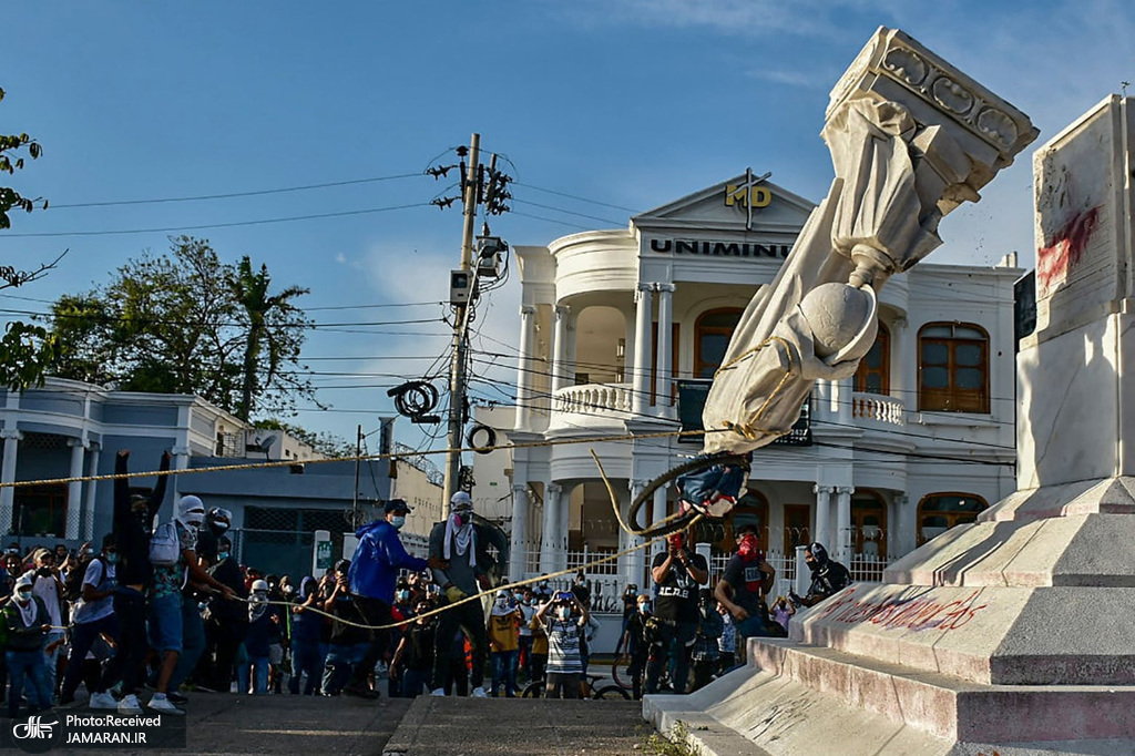 معترضان کلمبیایی در حال پایین کشیدن مجسمه کریستف کلمب + عکس