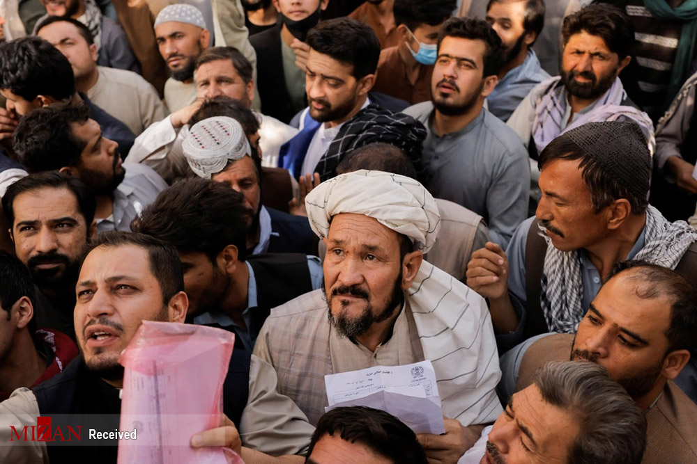 تهدید با اسلحه برای برقراری نظم صف پاسپورت در کابل +‌ عکس