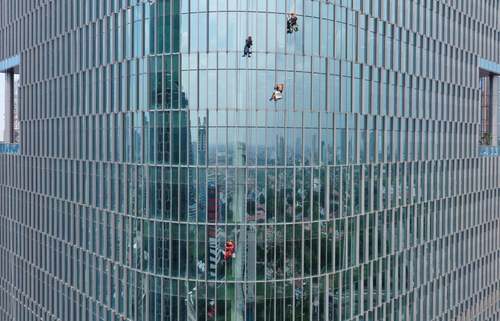 نمایی جالب از تمیز کردن شیشه های یک برج در جاکارتا + عکس