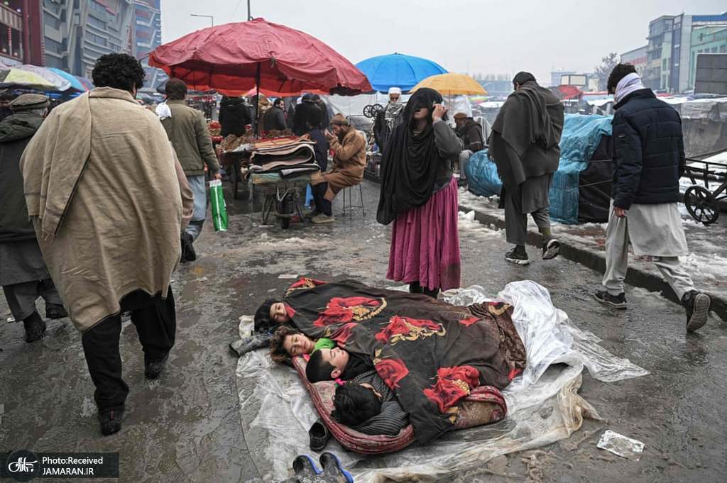 درخواست کمک زن افغان از رهگذران در یک روز سرد برفی + عکس