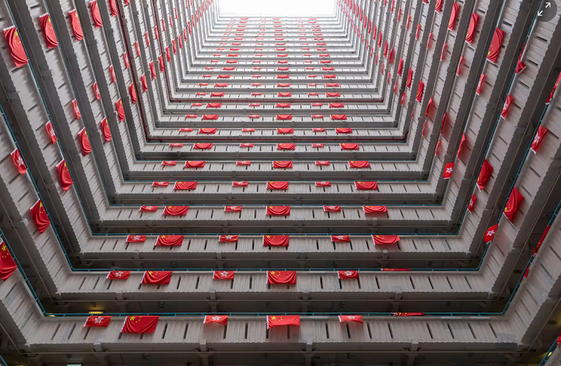 تزئین نمای خارجی یک ساختمان مسکونی عمومی با پرچم چین در هنگ کنگ + عکس