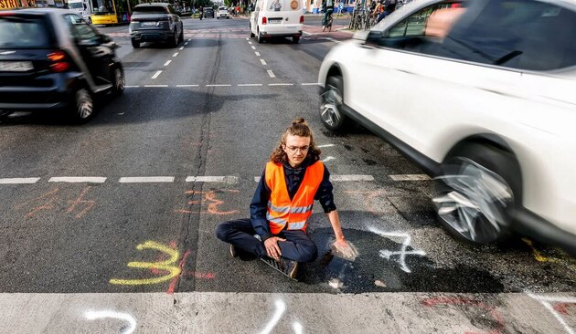 چسباندن دست به کف خیابان توسط معترضان محیط زیستی در آلمان + عکس