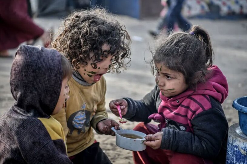 کودکان فلسطینی در حال خوردن یک وعده غذای گرم + عکس