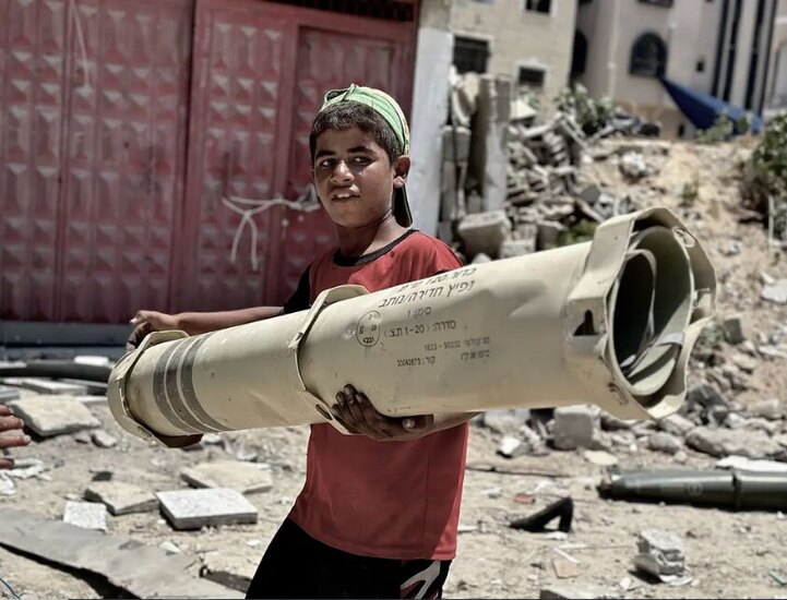 بقایای یک راکت اسرائیلی در دستان نوجوان فلسطینی در شهر خان یونس‌ + عکس