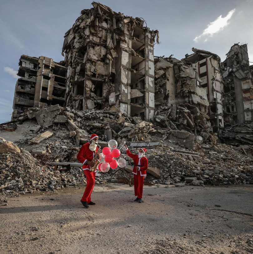 دو جوان فلسطینی با لباس بابانوئل در ویرانه‌های غزه