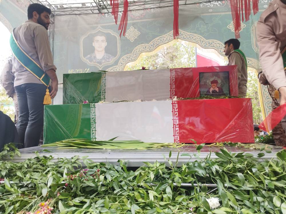 تصویر ادای احترام شهید جمهور به قرآن کریم بر روی پیکر  مدافعین قرآن 