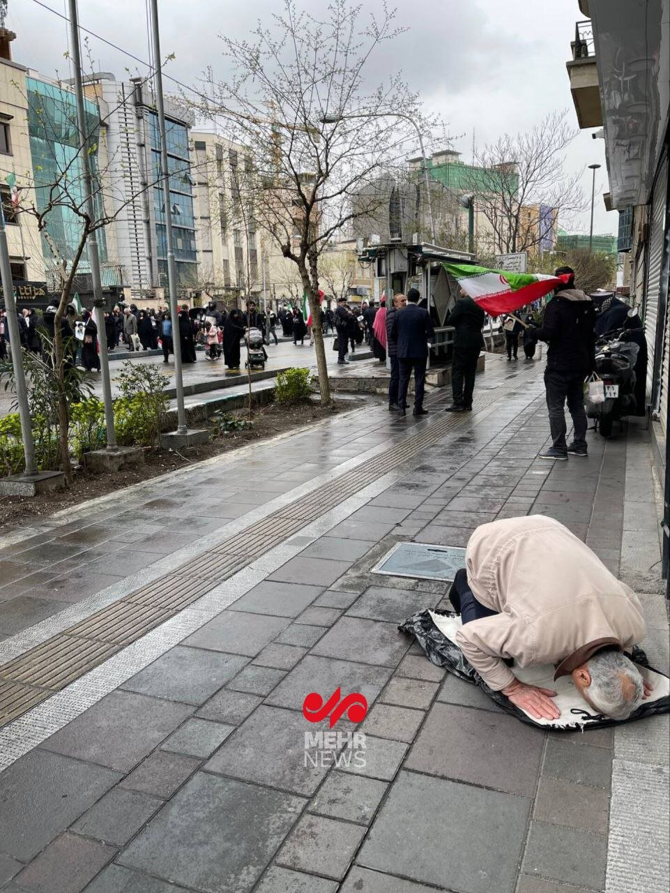 نماز خواندن یک مرد تهرانی در حاشیه راهپیمایی روز قدس بعد از حمله جنگنده‌های آمریکایی - اسرائیلی+ عکس