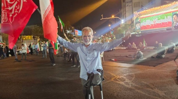 یک کهنه‌سرباز جنگ که پرچم ایران را در تجمعات شبانه به اهتزاز درمی‌آورد